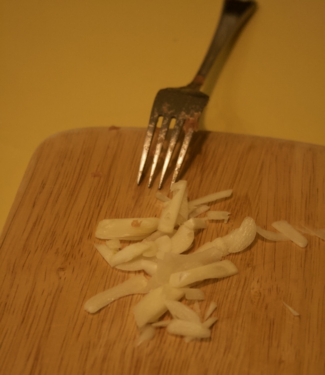 Kleingeschnittener Knoblauch auf einem Schneidebrettchen.